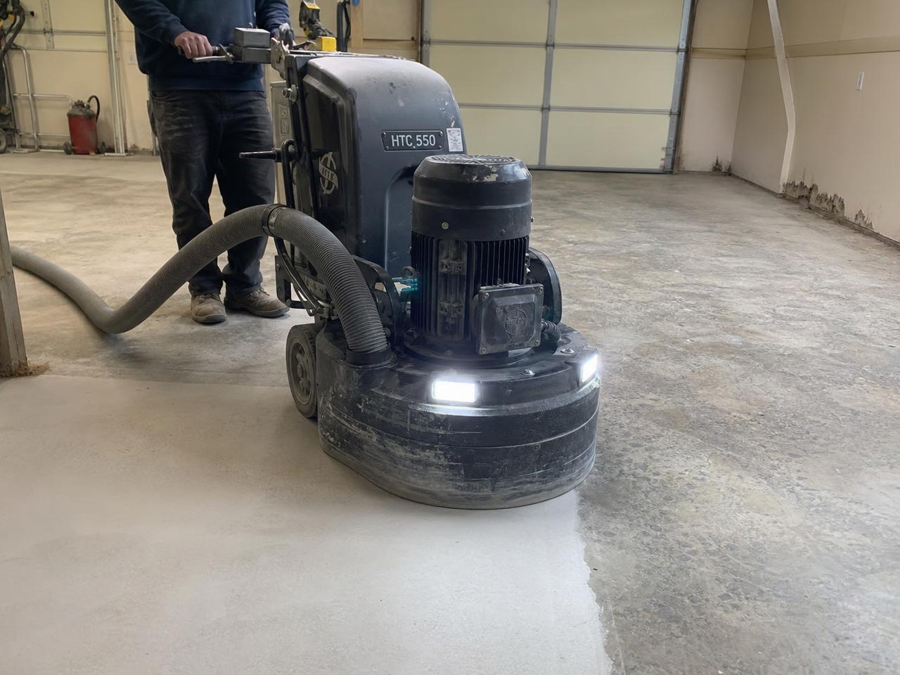 Concrete grinder profiling a garage slab before a coating is applied
