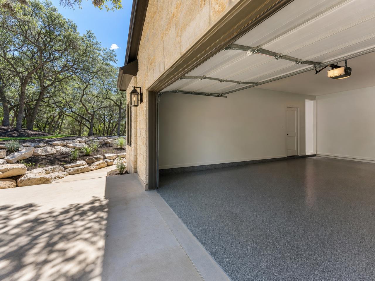 Austin hill country garage with a charcoal flake coated floor and limestone outside