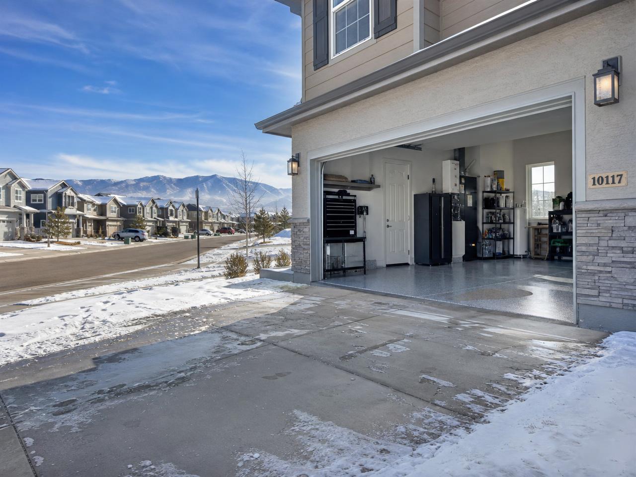 Colorado Front Range home with a snow-dusted driveway and attached garage