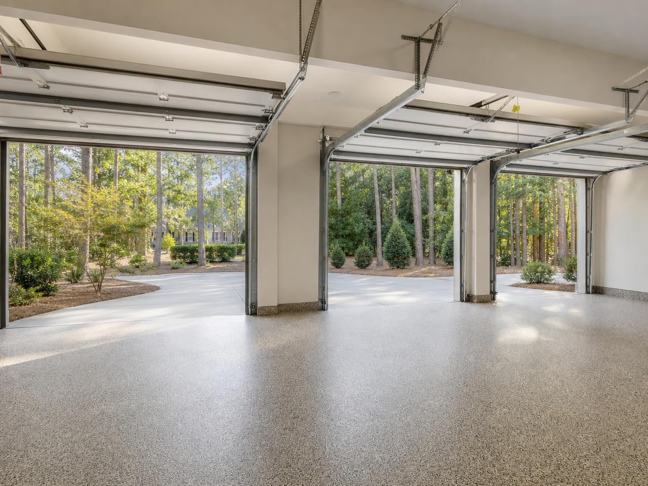 Raleigh three car garage with a flake coated floor and pine trees outside