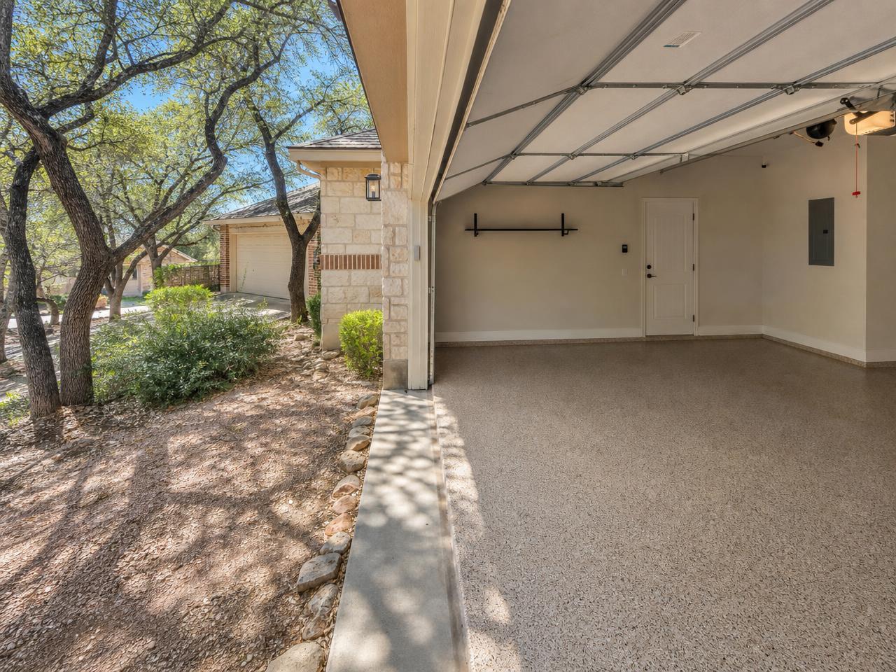San Antonio garage with a tan flake coated floor and dry caliche soil outside